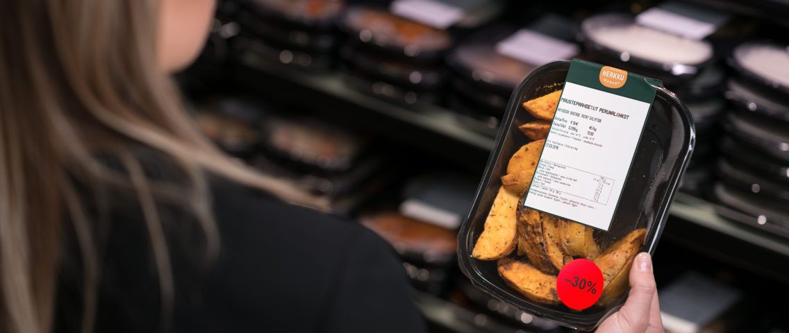 A person holding a package of potatoes.